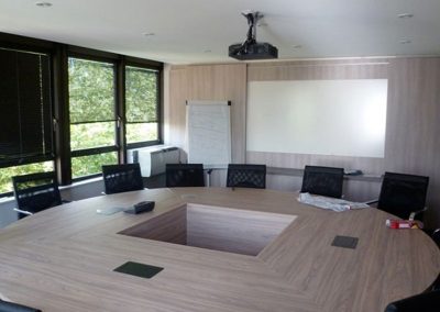 salle de réunion avec des chaises et une table en bois